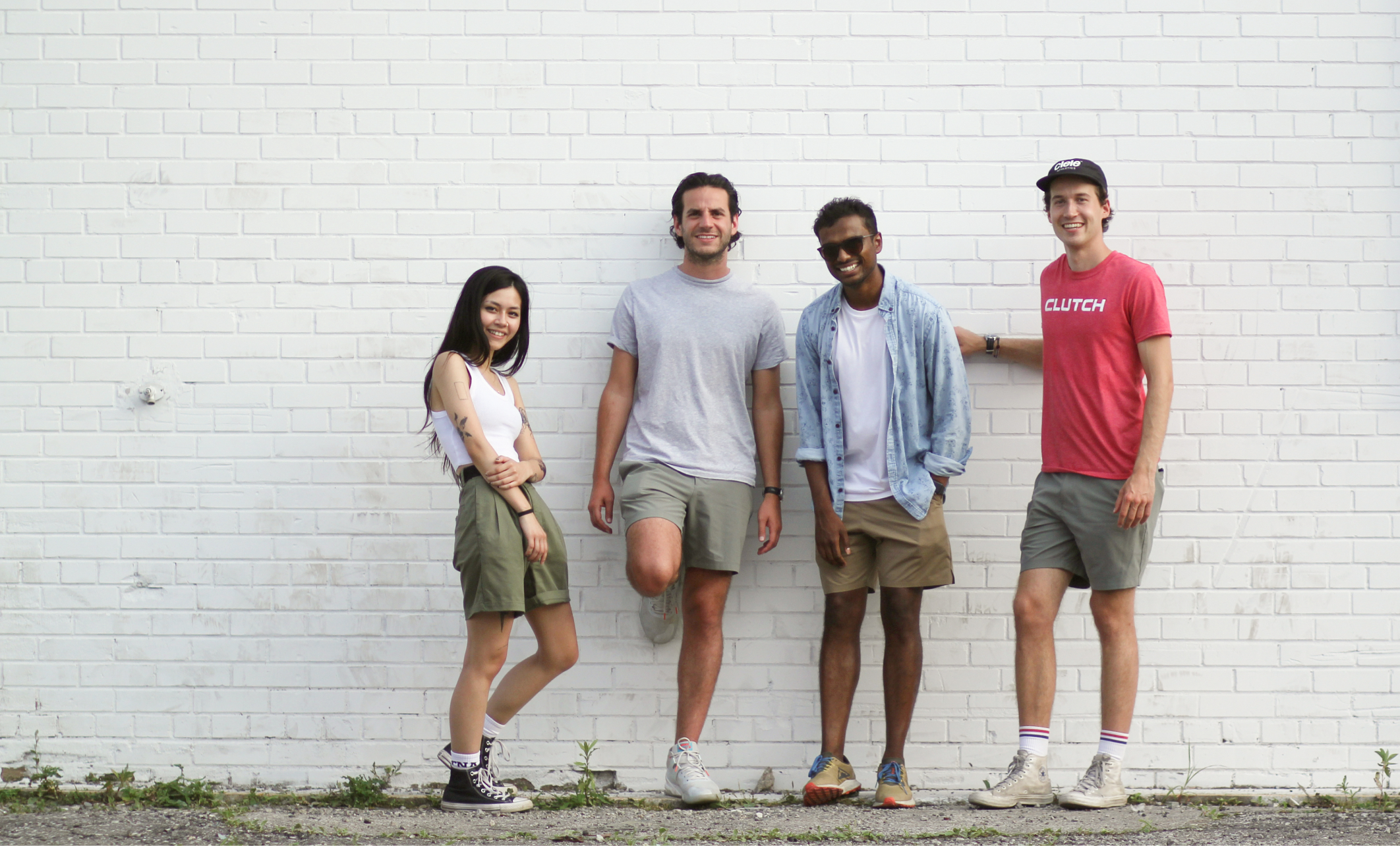 group of people standing against a brick wall