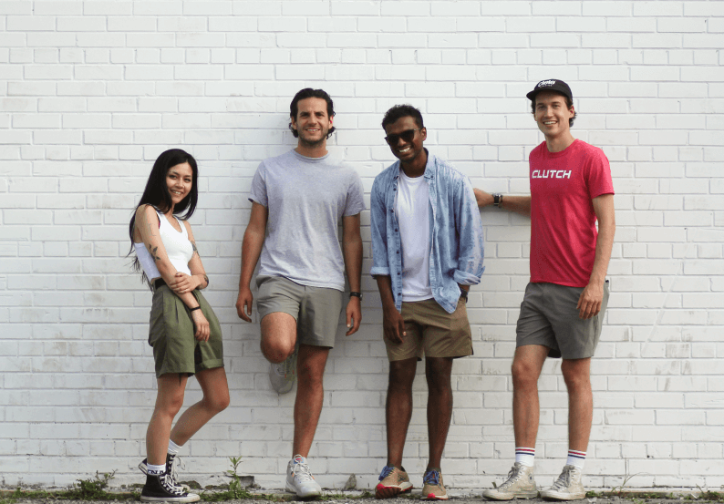 group of people standing against a brick wall